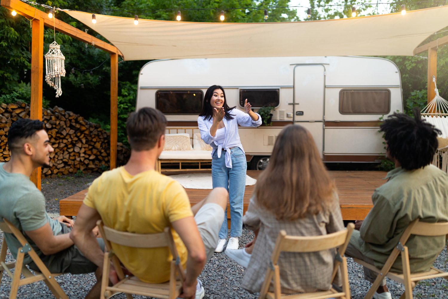group of friends outside rv playing charades how to have fun on a motorhome trip
